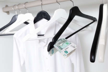 Russian rubles and empty clothes hangers in the wardrobe.の写真素材
