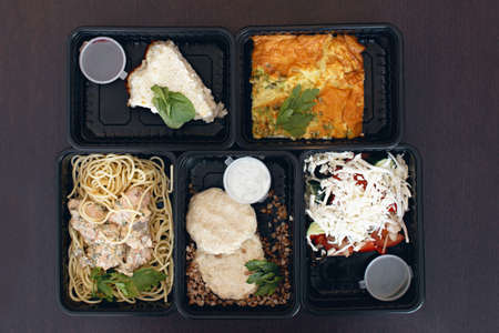 A variety of dietary food in a plastic packaging on a wooden background, top view. The concept of...