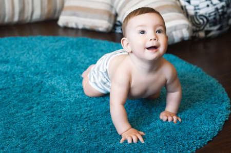 childhood, babyhood and people concept - hands of baby crawling on floor or carpetの写真素材