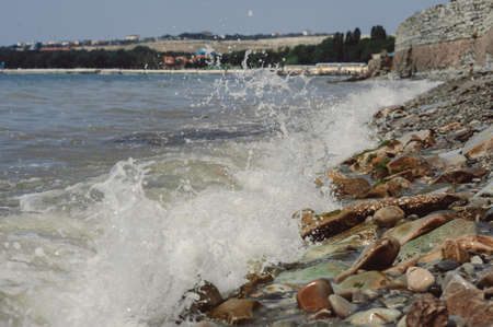 tidal bore. waves are beating against stones.の写真素材