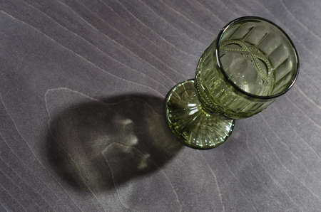 empty crystal green wine glass with a pattern, on a dark wooden background.の写真素材