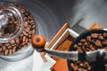 Ancient, hand-held coffee grinder with coffee beansの写真素材