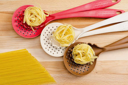 Homemade pasta in colander on wooden backgroundの写真素材