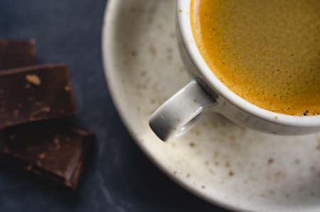 macro photo. light cup of black coffee with chocolate on the rustic table from a height. bokehの写真素材