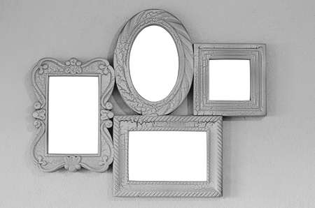 A collage of four empty photo frames on a gray wall, decor layout. Isolated on white backgroundの写真素材