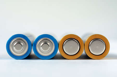 Four blue-golden AA batteries close-up on a white background. shallow depth of field, macroの写真素材