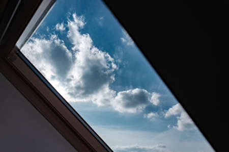 Attic. View from the window. View of the sky from the window. Skylight. Light in the houseの写真素材