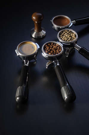 four holders with green, roasted, ground, and hot coffee and tamper, equipment for making freshly brewed coffeeの写真素材