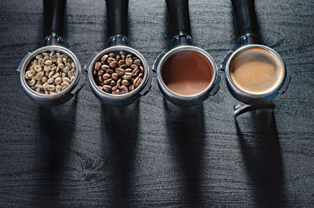 four holders with green, roasted, ground, and hot coffee and tamper, equipment for making freshly brewed coffeeの写真素材