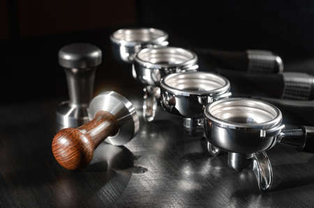 four holders with green, roasted, ground, and hot coffee and tamper, equipment for making freshly brewed coffeeの写真素材