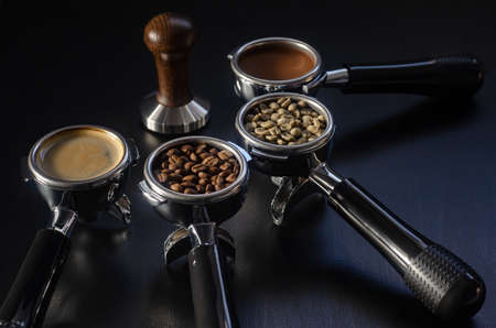 four holders with green, roasted, ground, and hot coffee and tamper, equipment for making freshly brewed coffeeの写真素材
