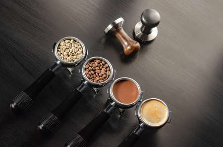 four holders with green, roasted, ground, and hot coffee and tamper, equipment for making freshly brewed coffeeの写真素材