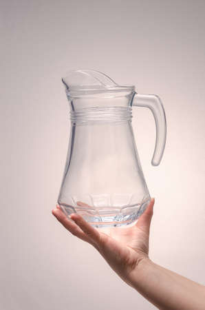 hand holds a carafe for drinks on a white background. isolateの写真素材