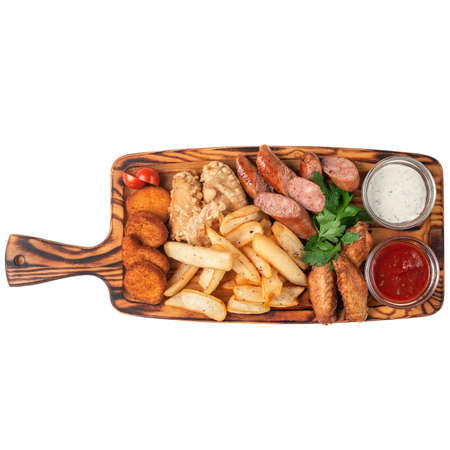 Chicken wings, sausages, nuggets, with katofel and barbecue sauce, promidorka and parsley. Wooden board for filing, on a white background. Isolateの写真素材
