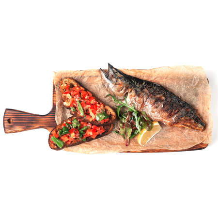 Croutons with roasted vegetables, fish and lemon, on a wooden board for serving. Isolateの写真素材