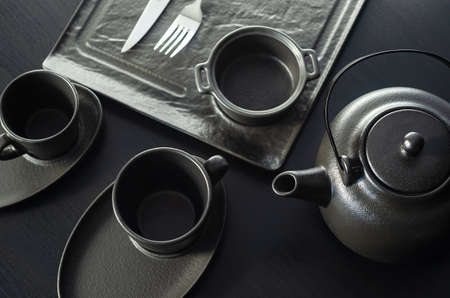 Set for the tea ceremony. Big clay teapot and cups on wooden background. Foreground. Copy space, space for textの写真素材