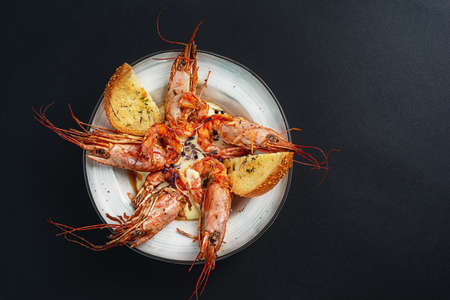 dishes with langoustines, in a plate on a black background. view from above. copyspace.の写真素材