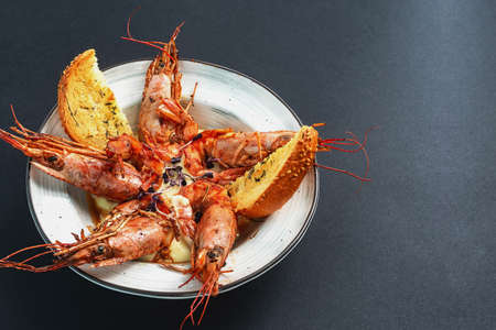 dishes with langoustines, in a plate on a black background. view from above. copyspace.の写真素材