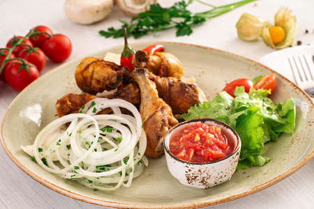 Fried chicken leg with tomato sauce and mixed salad in a serving dish. Copyspaceの写真素材