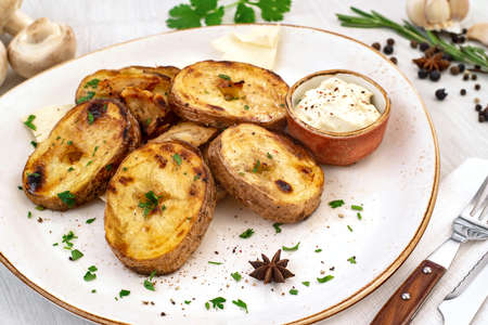 Rustic baked potato with cream sauce and spices on a serving platter. Copyspace.の写真素材