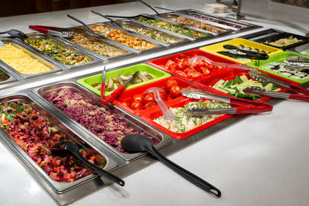 Serving vegetables and salads, self-service restaurant. vegetables tomatoes, cucumbers, marinade....