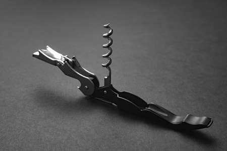Opened sommelier knife with corkscrew and bottle opener, professional waiter knife, on black...