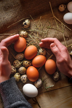 Fresh, raw eggs lie on the grass. Wood background. Texture of burlap. Organic background. Healthy eating. Easter composition.の写真素材