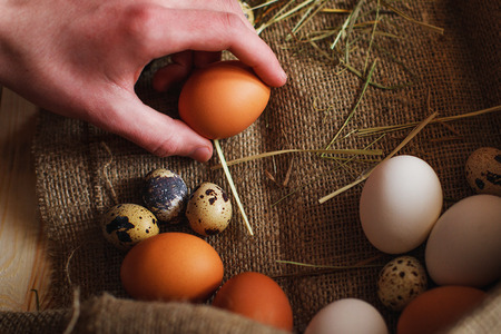 Fresh, raw eggs lie on the grass. Wood background. Texture of burlap. Organic background. Healthy eating. Easter composition.の写真素材