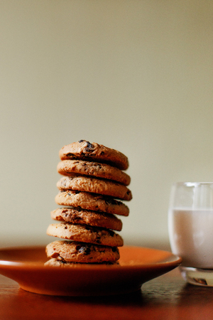 Tasty cookies on the table in a plate. A glass of fresh homemade milk. Morning breakfast. Mom cooked...