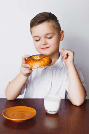 The young boy was tired of waiting. Morning, healthy breakfast, homemade milk and a delicious bagel. The boy is tired.の写真素材