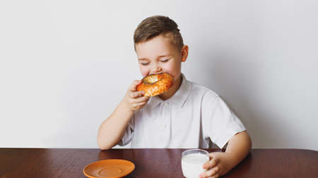 The young boy was tired of waiting. Morning, healthy breakfast, homemade milk and a delicious bagel. The boy is tired.の写真素材