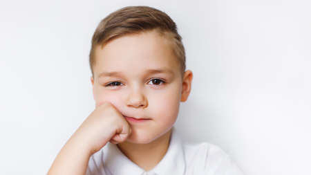 Portrait of a young boy of caucasian against a white wall.の写真素材