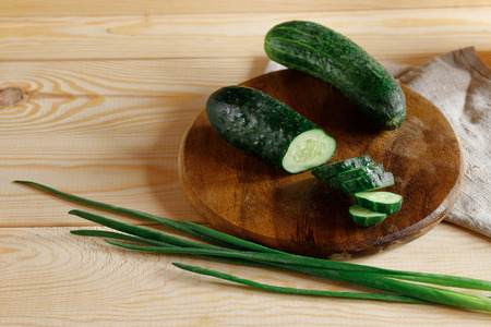 Fresh, green cucumbers sliced on cutting board with green onion. Organic product. Healthy vegetablesの写真素材