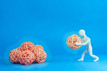 business idea concept. a man made of white plasticine is holding a shining ball in his hands, which...