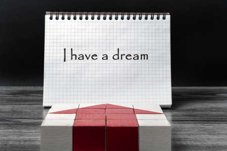 Mosaic of children's cubes in the form of a red arrow pointing to a standing Notepad. Motivational inscription in the notebook: "I have a dream".の写真素材