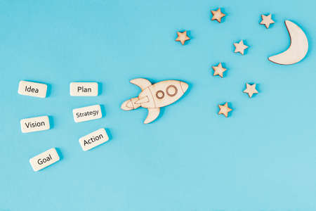 Motivational concept, development concept, startup. On a blue background, a rocket is flying away to the stars.の写真素材