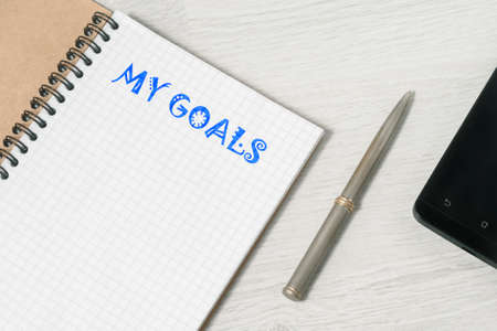 My goal concepts with text on notepad with accessories on white desk table backgroundの写真素材