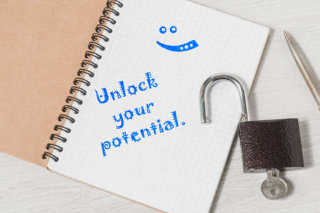 UNLOCK YOUR POTENTIAL motivational quote written in notebook