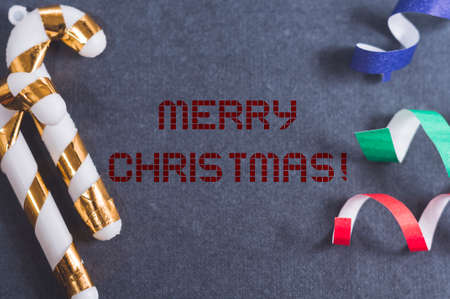 Christmas greeting card. The inscription in the center of happy Christmas. Dark background.