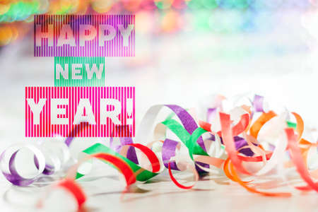 Happy new year greeting card. Bokeh in the background, scattered confetti in the foreground. Selective focus.の写真素材