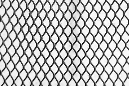 Macrophotography of a metal grid. White background. Repeating element.の写真素材