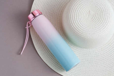 A large white ladies' beach hat with a pink and blue for drinks. The lid on the is pink.