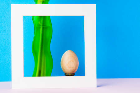 Still life green vase and egg in a white frame on a blue background.の写真素材