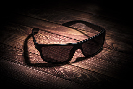 Dark glasses on the wooden table