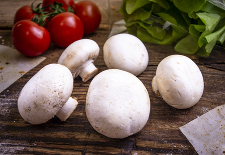 Cherry tomatoes, salat and mushrooms on rustic backgroundの写真素材