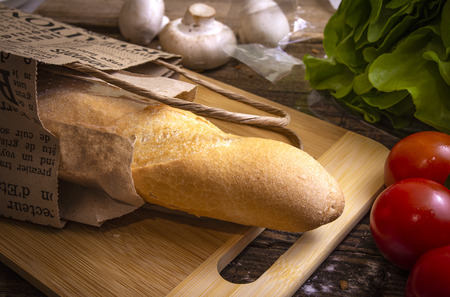 Baguette, cherry tomatoes, salat and mushrooms on rustic backgroundの写真素材
