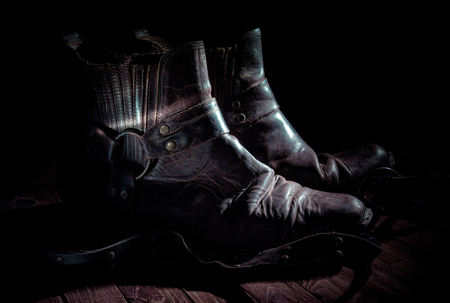 Old vintage cowboy boots in low keyの写真素材