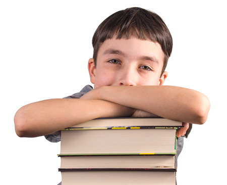 Cute boy with a stack of books smiling on white backgroundの写真素材