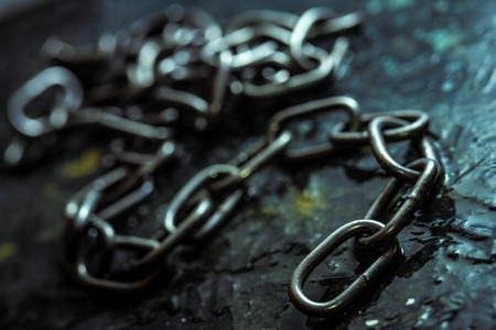 Broken iron chain on dark stone backgroundの写真素材