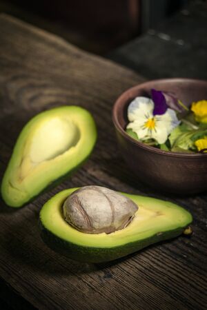 Green avocado and fresh salad on rustic kitchen backgroundの写真素材
